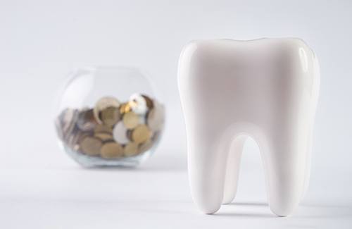 a tooth and coins in a jar in the background
