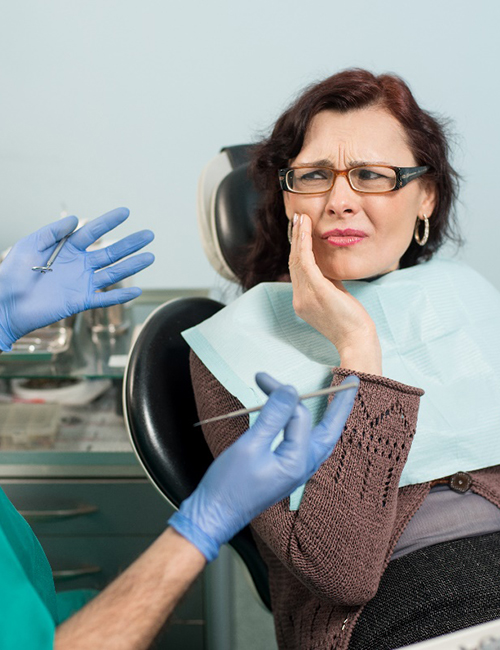 A woman talking with a dentist about her dental emergency