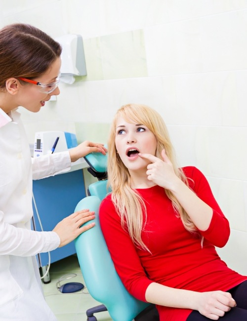 Woman pointing to mouth before tooth extractions