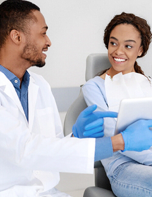 Dentist and patient smiling during consultation at office