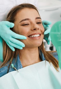 young woman smiling in dental mirror 