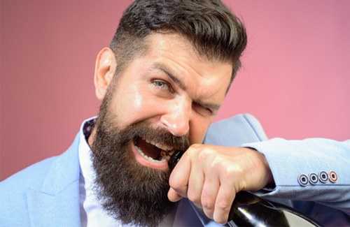man opening bottle with teeth  