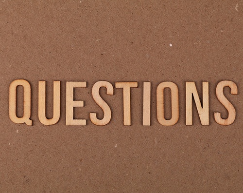 Questions spelled using wooden letters on brown background