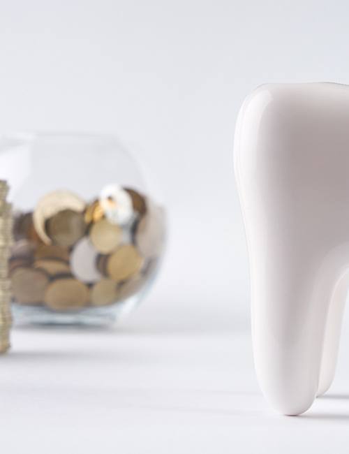 Tooth next to a pile of coins