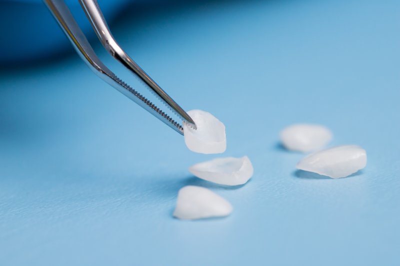 A dentist grabbing veneers with tweezers