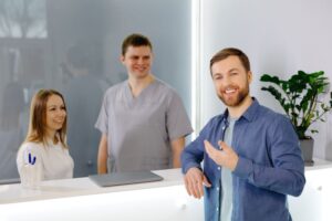 Happy patient standing at dental office front desk